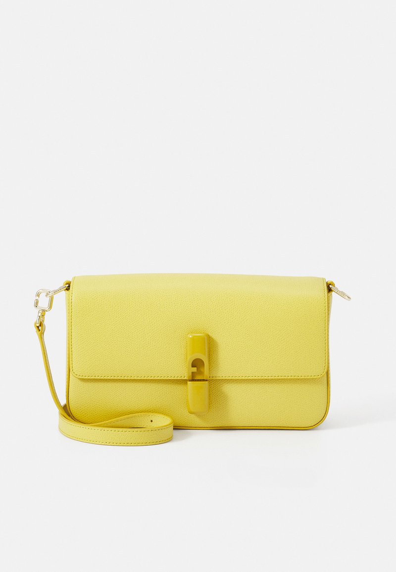 Dzeltena ādas crossbody soma ar teksturētu virsmu. Aprīkota ar spiedpogu aizdari un regulējamu siksnu. Vienkārša taisnstūra forma.