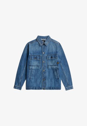 Giacca in denim blu con bottoni, due grandi tasche a patta sul petto e maniche lunghe, appoggiata su uno sfondo bianco.