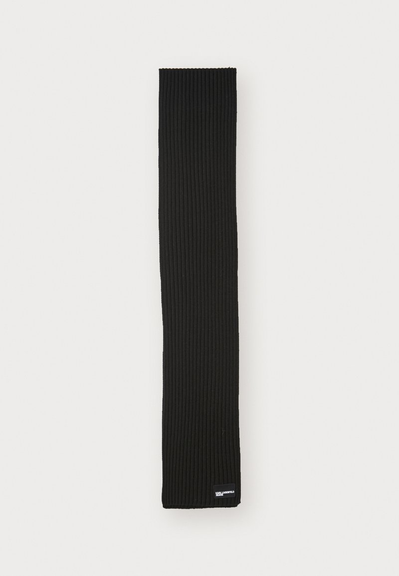 Cachecol preto canelado, em forma retangular, feito de tecido macio, apresentando uma borda dobrada com um pequeno rótulo da marca no canto inferior.
