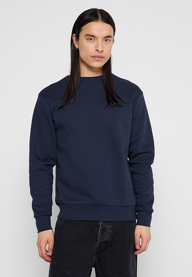 Marinblå sweatshirt i mjukt tyg, med rundad hals, ribbade muddarna och fållen, i avslappnad passform och med en minimalistisk design.