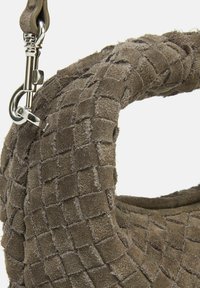 Borsa in suede marrone con un motivo intrecciato testurizzato, caratterizzata da una clip in metallo argentato e da una forma arrotondata e morbida.