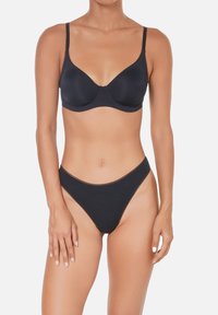Soutien-gorge noir et string taille haute assorti. Tissu lisse, design avec armatures, bretelles réglables et style minimaliste sans ornements.