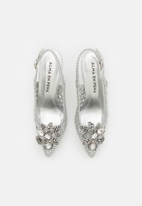 Scarpe slingback argento con tacco alto, presentano una texture intrecciata e decorazioni floreali con pietre e perline. Design a punta.