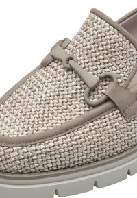 Mocassin en tissu beige tissé avec bordure taupe, semelle en caoutchouc et détail décoratif en métal mat en forme de mors sur le dessus.