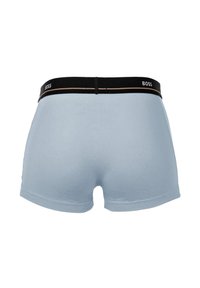 Boxer-briefs bleu clair en tissu doux, dotés d'une ceinture noire avec le nom de la marque "BOSS" et d'une ligne d'accent dorée.