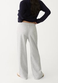 Lichtgrijze sweats met een relaxed fit en een elastische tailleband, gemaakt van zacht katoen, met een gladde textuur en een minimalistisch ontwerp.