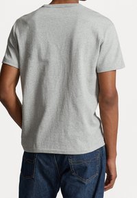 Šedé bavlněné tričko s krátkými rukávy a kulatýmVýstřihem, s volným střihem a hladkou strukturou, zobrazené ze zadní strany.