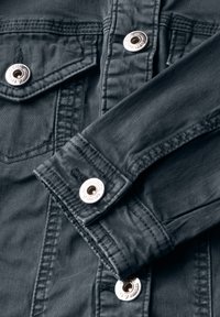 Mörkgrå denimjacka med silverfärgade tryckknappar, bröstfickor och synliga sömnadsdetaljer vid kragen och ärmslut. Mjuk textur.