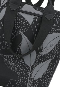 Bolsa tote negra con un patrón de hojas grises y acentos punteados. Tiene asas negras resistentes y un cierre con cremallera para un almacenamiento seguro.