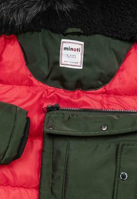 Grüne und rote, gepolsterte Jacke mit einem fleecegefütterten Kragen, Reißverschluss und Druckknopfverschlüssen, texturiertem Material und Seitentaschen.