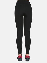 Czarne legginsy z wysokim stanem o gładkiej fakturze, charakteryzujące się dopasowanym krojem. W połączeniu z czarno-czerwonymi butami sportowymi.