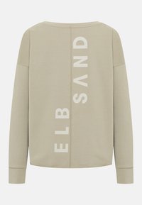 Lichtbeige sweatshirt met lange mouwen, voorzien van verticale witte letters en een eenvoudige, relaxte pasvorm. Soepele, zachte textuur.