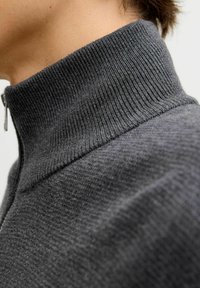 Tumehall villane sall, millel on kõrge ribadega krae ja sile tekstuur; kaeluses on lukk sulgemiseks ja minimalistlik disain.