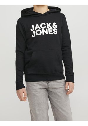 Czarna bluza z kapturem z białym nadrukiem "JACK & JONES" z przodu, z kieszenią kangurzą i ściągaczami na rękawach, noszona z jasnoszarymi spodniami.