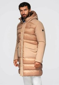 Beige pufferjas met een capuchon, voorzien van horizontaal gestikte delen, twee voorkeurs, een drukknoopsluiting en een gestructureerde afwerking.