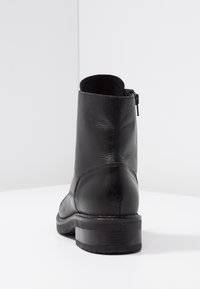 Czarne skórzane botki za kostkę z okrągłym noskiem, niskim obcasem blokowym i zamkiem błyskawicznym z boku. Gładka tekstura z subtelnymi detalami w stębnowaniu.