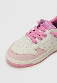 Αθλητικά υποδήματα με λευκό δερμάτινο επάνω μέρος και απαλές ροζ λεπτομέρειες. Διαθέτουν ροζ κορδόνια, διάτρητο σχέδιο και υφασμάτινη σόλα από καουτσούκ.