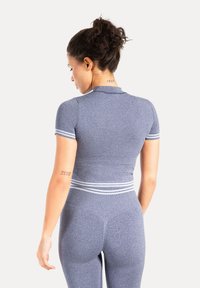 Figursyet, kortærmet sportstop i tekstureret blåt stof med hvide stribede accenter ved manchetter og taljebånd. Indeholder diskrete logodetaljer.
