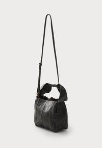 Borsa a spalla in pelle nera con una finitura morbida e testurizzata, design plissettato, tracolla regolabile e dettagli in hardware dorato.