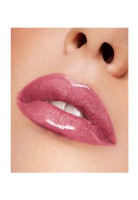 Błyszczący kolor ust w delikatnym różowym odcieniu, o gładkiej konsystencji i subtelnym blasku, podkreślający pełne usta i naturalny połysk.