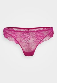 String rose en dentelle avec un motif floral, des bords festonnés et une ceinture unie. Tissu léger et semi-transparent.