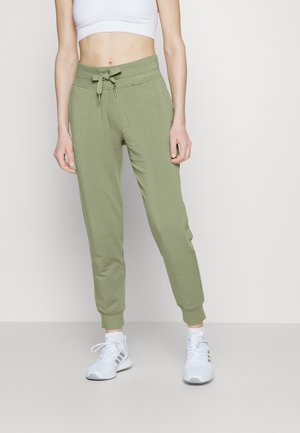 Lysegrønne joggingbukser lavet af blødt stof med elastisk taljebånd og snøre, tilspidsede manchetter og sidelommer.