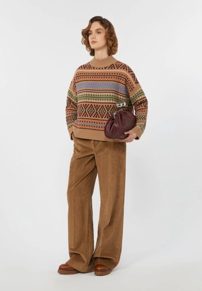 Maglione lavorato a maglia con motivi geometrici multicolori, abbinato a pantaloni a gamba larga in corduroy marrone e una borsa a pochette bordeaux; scarpe con plateau marroni.