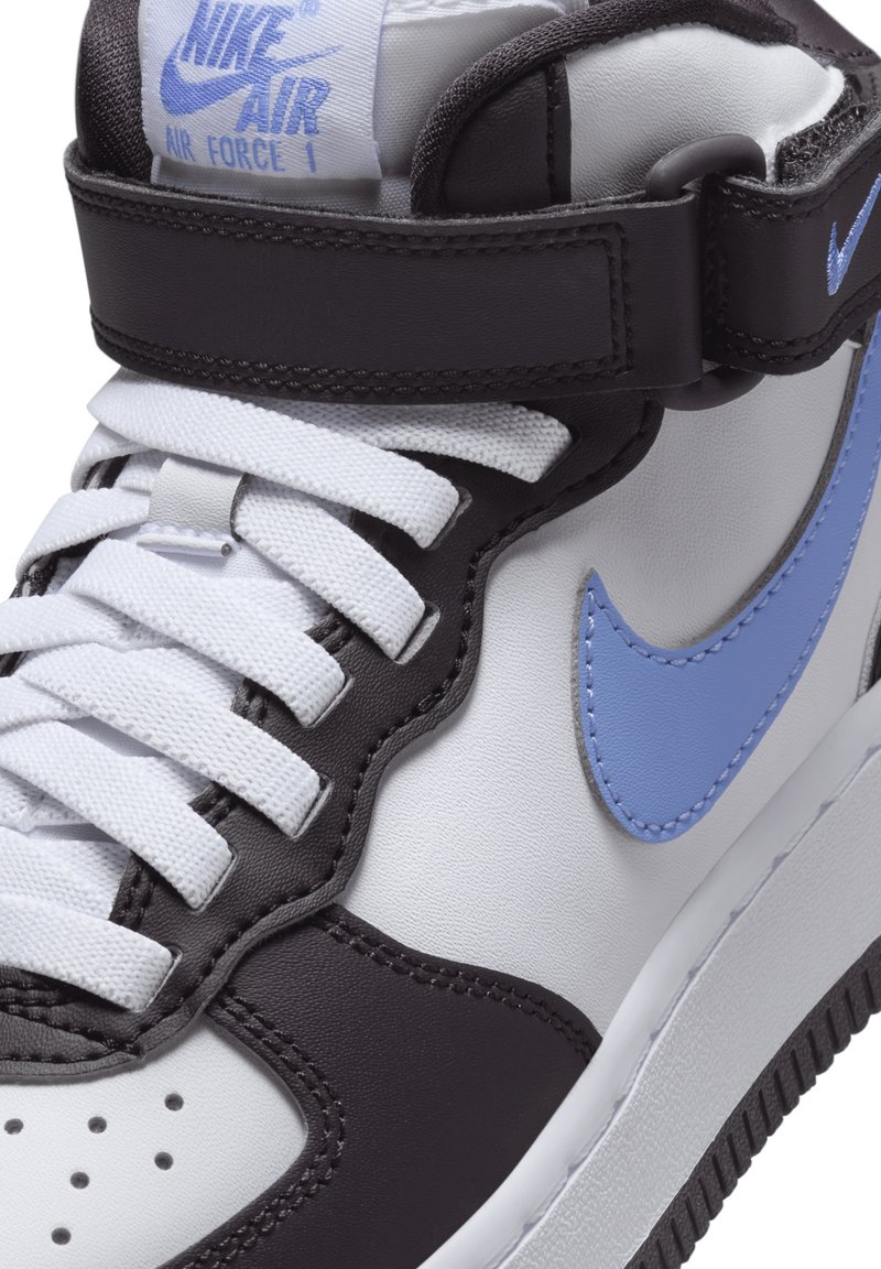 Sneakers Nike Air Force 1 w białej i czarnej skórze z jasnoniebieskimi akcentami, z zawiązywaniem i paskiem na kostce. Widoczna teksturowana podeszwa.