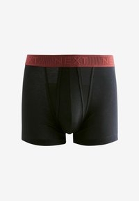 Črne boksarice z rdečim elastikastim pasom, na katerem je vklepan logotip "NEXT". Narejene so iz mehkega materiala, z prilagojenim krojem in podporo spredaj.