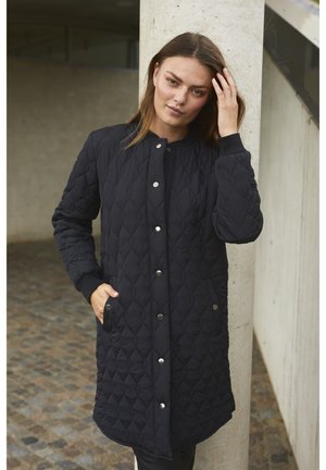 Schwarzer gesteppter Mantel mit einer Knopfleiste, seitlichen Taschen und gerippten Bündchen. Verfügt über ein Rautenmuster auf dem Stoff und ein mittellanges Design.