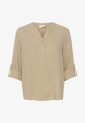 Bež värviga nupukleidiga pluus V-kaeluse, kolmandiku pikkusega varrukate ja rulli-tabsiga mansettidega. Valmistatud kergest kangast, millel on sile tekstuur.