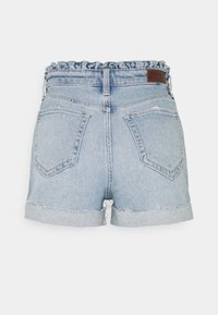 Jeansshorts med en ljusblå tvätt, volangmidja, uppvikt fåll och två bakfickor med en subtil sömdetalj.