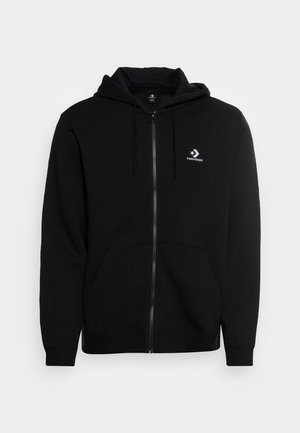 Sweat à capuche zippé noir avec cordons, poches avant et logo Converse blanc sur la poitrine gauche sur un fond uni.
