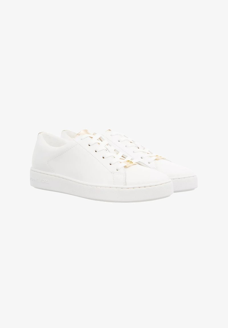 White leather sneakers with a smooth texture, flat rubber soles, and round toe. Features gold accents on the laces and minimalistic design.