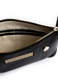 Zwarte leren handtas met gouden hardware, ritsafsluiting en een crèmekleurige voering. Het interieur heeft twee compartimenten met zwarte strepen.