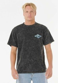 Camiseta de algodón negra lavada con cuello redondo, mangas cortas y logo en el pecho en azul. Textura suave con una estética desvanecida.