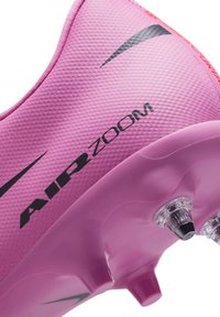 Rosa fotbollssko med texturerad ovandel, med "AIR ZOOM"-logotyp i svart. Klara dobbar på sulan förbättrar grepp och prestanda.