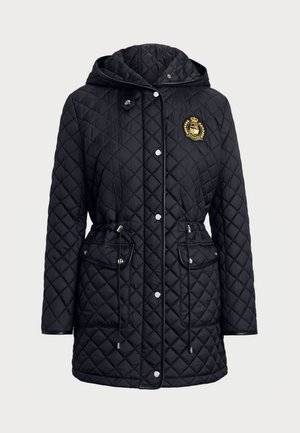 Veste matelassée noire avec capuche, ornée d'un emblème doré, poches zippées et cordons de taille ajustables. Texture lisse et design moderne.