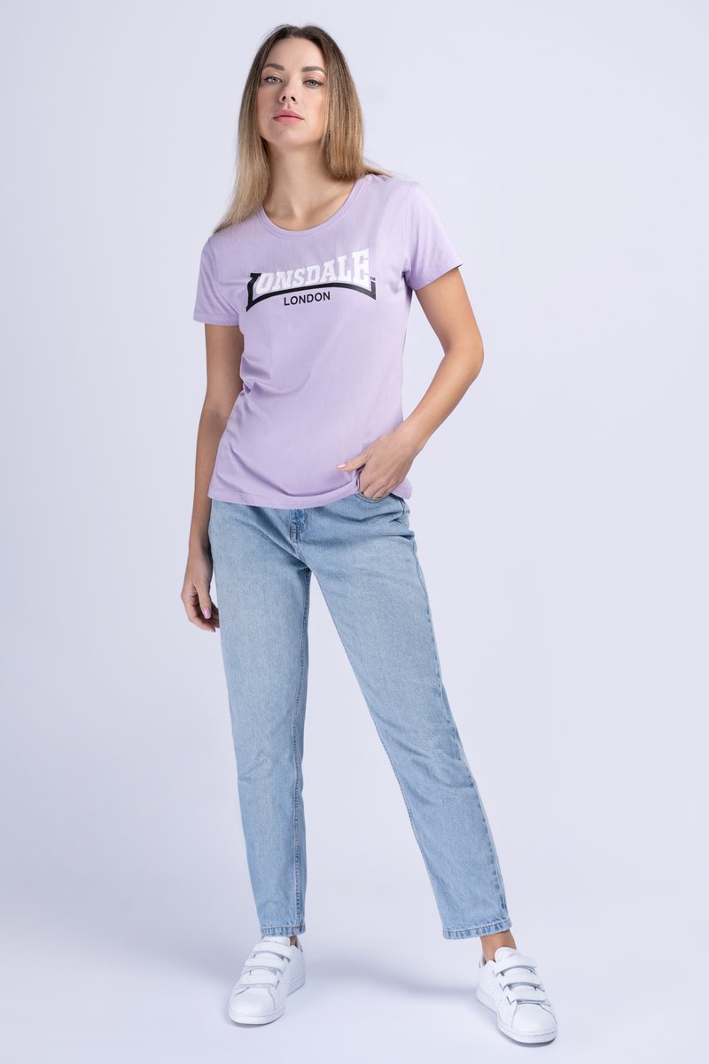 Levanduľové tričko s krátkym rukávom a čierno-bielou grafikou "Lonsdale London", kombinované s svetlo modrými džínsami rovného strihu a bielymi teniskami.