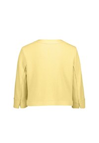 Žlutý, dlouhý rukáv pulovr s kulatým výstřihem, vyrobený z měkké tkaniny a s bočními rozparky na manžetách. Jednoduchý design, bez ozdob.