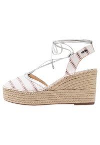 Białe sandały na koturnie espadryle z czerwonymi i czarnymi paskami, z plecioną juty podeszwą i srebrnymi sznurówkami, otwarty przód i wiązania wokół kostki.