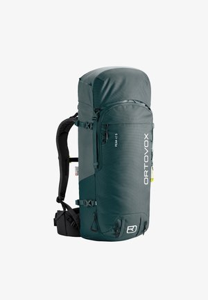 Großer, dunkelgrüner technischer Wanderrucksack mit mehreren Riemen, Seitentaschen und "ORTOVOX"-Markierung auf der Vorderseite.