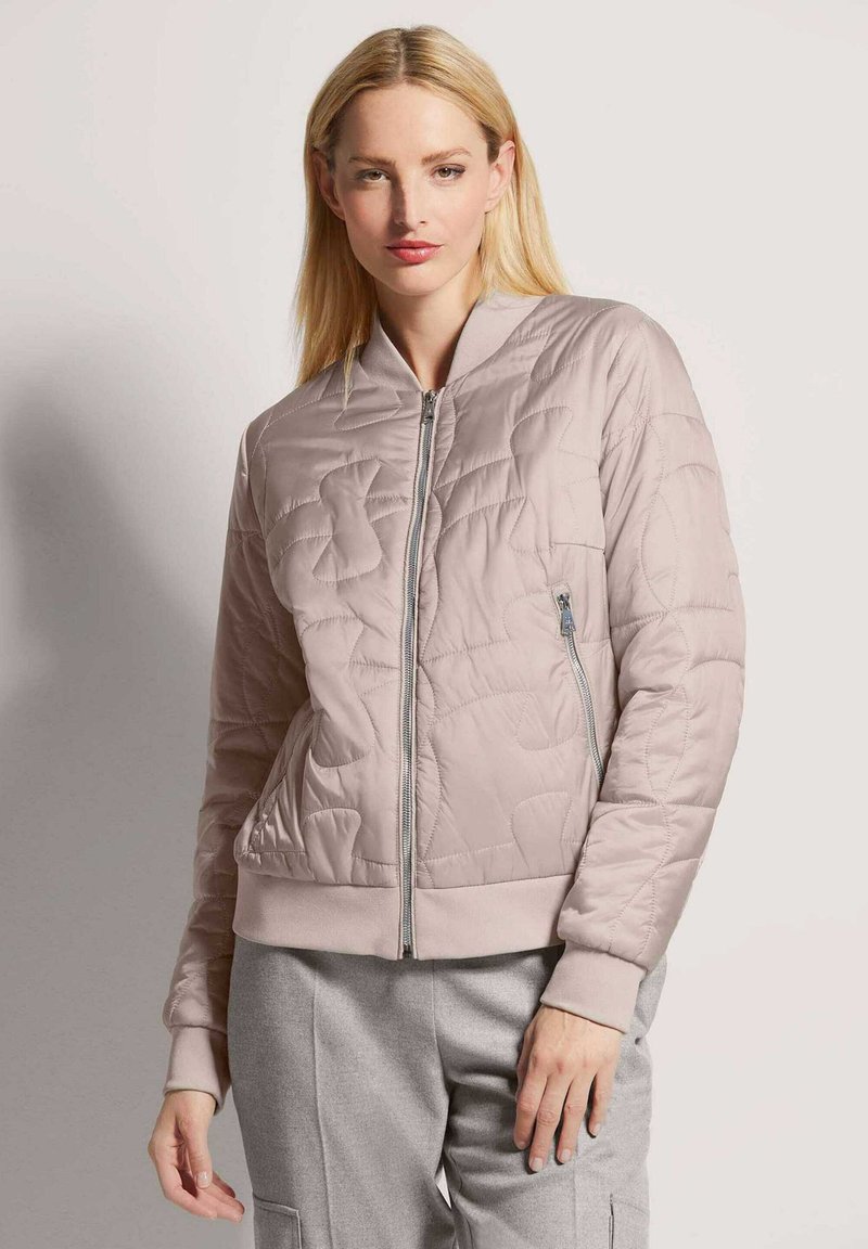 Quilted Bomberjacke in hellem Rosa, mit Reißverschluss vorne, gerippten Bündchen und Saum sowie seitlichen Taschen mit Reißverschlussdetail. Weicher, glänzender Stoff.
