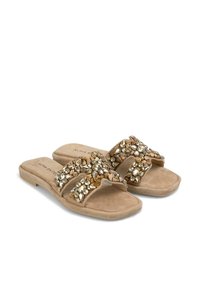 Beige schuifsandalen met een suède textuur, voorzien van kruisschoenen versierd met natuurlijke stenen en heldere rhinestones. Plat zoolontwerp.