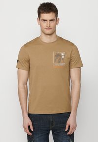 T-shirt en coton marron avec un graphisme de tigre et le texte « Japan Tokyo » à l'avant. Manches courtes et encolure ras du cou. Coupe décontractée.