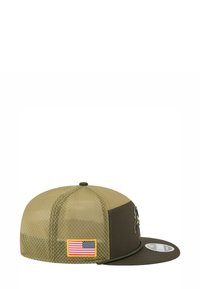 Casquette verte et beige avec des côtés en maille, visière plate et patch du drapeau américain. Présente un logo brodé dans des couleurs contrastantes.