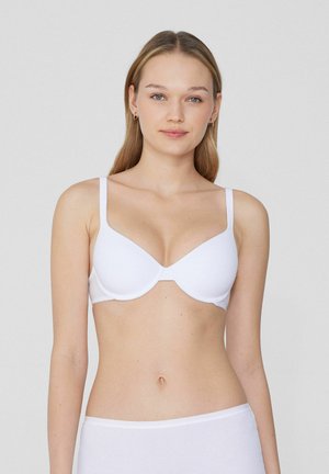 Soutien-gorge en forme de tasse blanche, moulée, avec des bretelles fines et un design sans couture, fabriqué à partir d'un tissu doux et lisse, présentant une silhouette simple et classique.