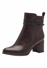 Stivaletto in pelle marrone con punta quadrata e tacco a blocco. Presenta due cinture nere testurizzate con piccole fibbie per un tocco di dettaglio.