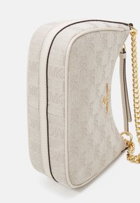 Jasnoczarna torebka typu crossbody z teksturowanej tkaniny, z wytłoczonym wzorem logo i złotym łańcuchem. Posiada kontrastowe ciemne wykończenia na krawędziach.