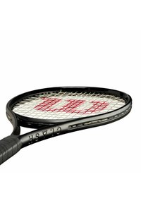 Tenniss racket met een zwart frame, een wit en rood snarenpatroon, en een gestructureerde grip voor verbeterde bediening. Heeft een gebogen kopvorm.